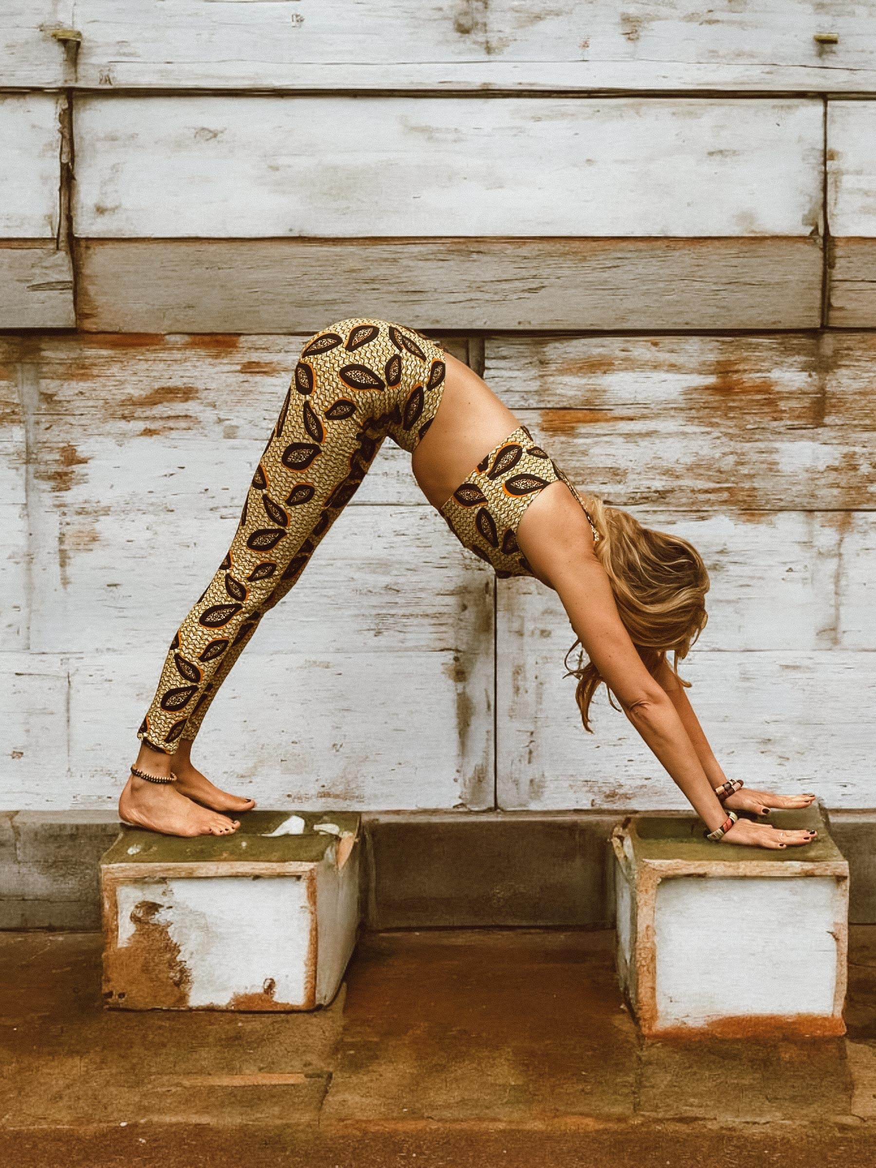 Woman in Papaya Terra leggings and bra. Colors black, orange and mustard yellow